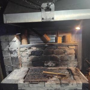 a large brick oven with a stone wall at ULA guest house in Ureki