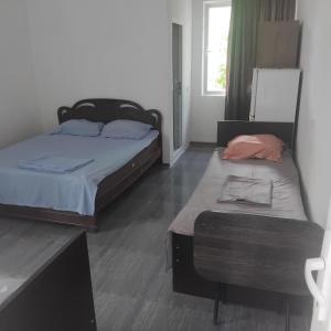 a bedroom with two beds and a ottoman in it at ULA guest house in Ureki