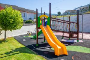 a playground with a slide in a park at Hotel Restaurante Glasgow in Villadesuso