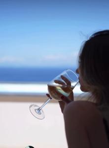 a woman drinking a glass of wine at Al Capri Suite & Private Pool in Capri