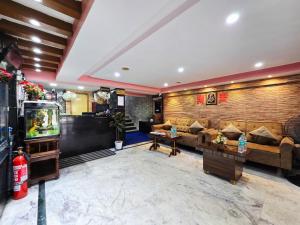a living room with a couch and a tv at Anandaloke Guest House in Kolkata