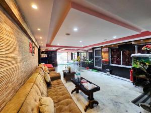 a living room with a large couch and a fish tank at Anandaloke Guest House in Kolkata