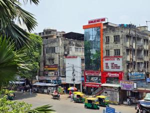 a busy city street with tall buildings and cars at Anandaloke Guest House in Kolkata