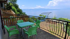 a table and chairs on a balcony with a view of the water at Apartments Viktor in Trpejca +6 photos