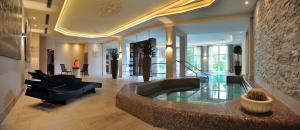 a living room with a large tub in a house at Kurhotel Grüttner mit eigenem Sole Thermal Schwimmbad 32 Grad und Saunalandschaft in Erwitte