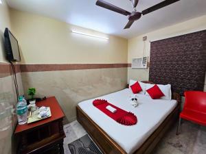 a bedroom with a bed with red pillows and a red chair at Anandaloke Guest House in Kolkata +37 photos