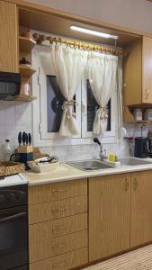 a kitchen with a sink and a window with curtains at All seasons Mountain escape in Vília