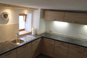 a kitchen with wooden cabinets and a sink and a window at Chalet Alte Mühle in Fügenberg +64 photos