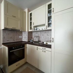 a kitchen with white cabinets and a sink at Budva Centar in Budva