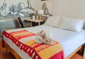 a bed with two stuffed animals sitting on it at Outsite Todos Santos - Formerly Perro Surfero Hotel Boutique in Todos Santos
