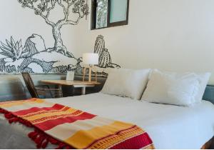 a bedroom with a bed with a blanket on it at Outsite Todos Santos - Formerly Perro Surfero Hotel Boutique in Todos Santos