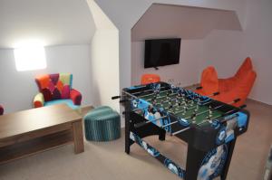 ein Wohnzimmer mit Tischfußball und Stühlen in der Unterkunft Transylvania Villa & Spa in Muntele Băişorii