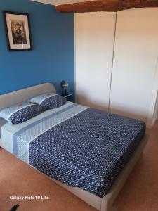 a bedroom with a bed with a blue wall at Montgrailloux - Chambilly in Chambilly