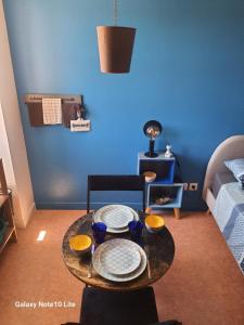a living room with a table and a blue wall at Montgrailloux - Chambilly in Chambilly