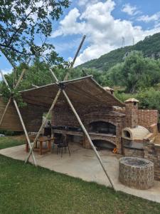 a large brick building with a table and a fireplace at Bamboo glamping in Kotor