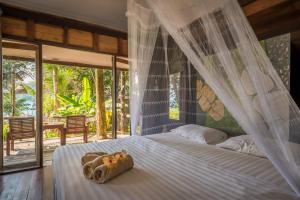 um quarto com uma cama e uma rede mosquiteira em Koh Kood Resort em Ko Kood