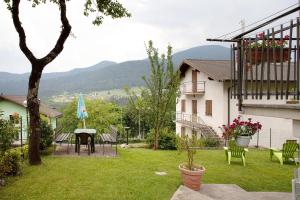 a yard with a table and chairs and a house at Casa Heidi in Castello Tesino