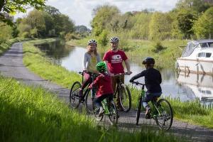 a group of people riding bikes next to a river at Canal View Lodge & Spa - Entire 3 Bed Lodge in Longford