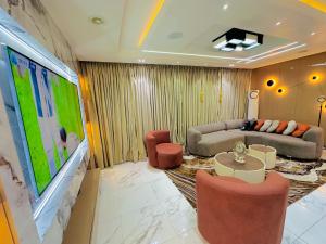 a living room with a couch and a tv at Armacruz Luxury Hotel And Apartment in Warri Airport