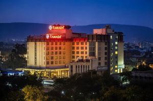 a building with a hotel sign on top of it at Ramada By Wyndham Jaipur in Jaipur