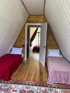 a attic room with two beds and an open door at Borjomi Tskhaoba in Borjomi