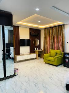a living room with a green couch and a television at Soilsmart haven in Abuja