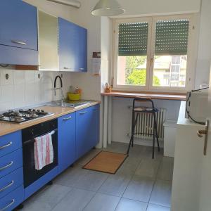 a kitchen with blue cabinets and a stove top oven at CASA VACANZE Matilde in Gavirate