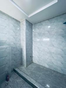 a bathroom with a stone wall with a shower at Soilsmart haven in Abuja +23 photos