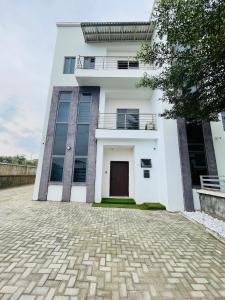 a white house with a brick driveway in front of it at Soilsmart haven in Abuja