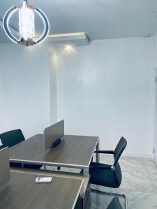 an office with a desk with a laptop and chairs at Soilsmart haven in Abuja