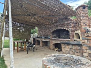 an outdoor patio with a brick oven and a table at Bamboo glamping in Kotor