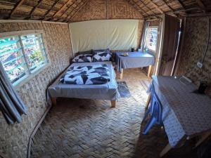 a room with two beds and a table in it at Asaro Mudman Cultural Lodge in Goroka