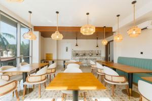 a restaurant with tables and chairs and windows at Abantu Hotel in Dar es Salaam