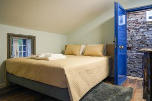 a bedroom with a bed with a blue door at Casas Martinho - O Baloiço in Piódão