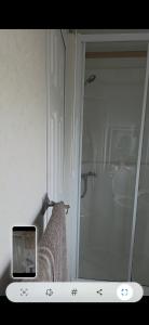 a bathroom with a shower and a clock on a counter at The Joanack Breeze in Withernsea +11 photos