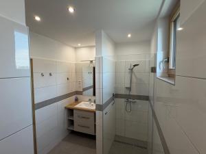 a white bathroom with a sink and a shower at Pater Apartman in Zalaegerszeg +103 photos