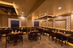 a restaurant with tables and chairs in a room at The Bayan Elegance Hotel in Jaipur