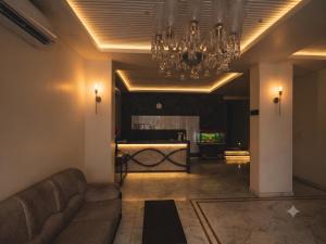 a living room with a couch and a chandelier at The Bayan Elegance Hotel in Jaipur
