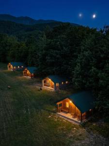 a group of cottages in a field at night at Cottages Serdar in Mojkovac