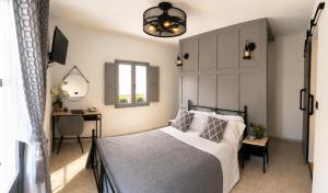 a bedroom with a bed and a desk and a window at Villa Otivar - Rio Verde in Otívar