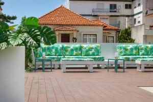 a group of couches sitting on a patio at Spirit Hotel Fonte Real in Monte Real