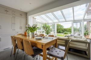 a kitchen and dining room with a wooden table and chairs at Forest View in Brockenhurst