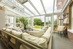 a conservatory with a couch in a room with windows at Forest View in Brockenhurst