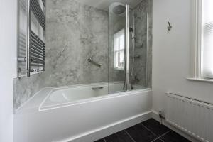 a white bath tub in a bathroom with a window at Forest View in Brockenhurst +51 photos