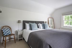 a bedroom with a bed and a chair and a window at Forest View in Brockenhurst
