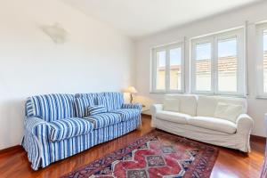 a living room with a couch and a chair at Hostdomus - Brezza Marina House in Alassio