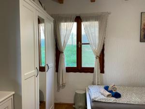a bedroom with a window and a teddy bear on a bed at Vila Hedona in Donji Milanovac