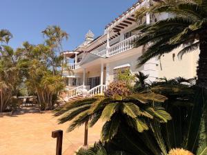 a large white house with palm trees in front of it at CASABA - Boutique - Torre del Mar in Torre del Mar