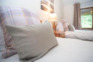 a bedroom with a bed with a pillow on it at The Barn - Old Mill Cottages in Ilfracombe
