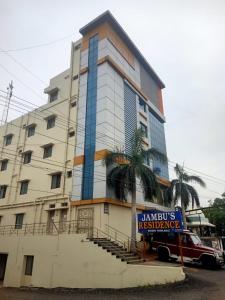 a tall building with a sign in front of it at jambu's residence in Karūr